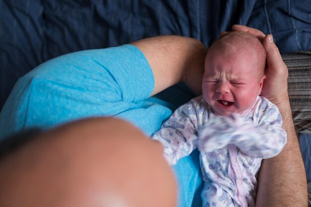 Колики у новорожденных: причины и лечение. Изображение младенца с болевыми спазмами в животе.